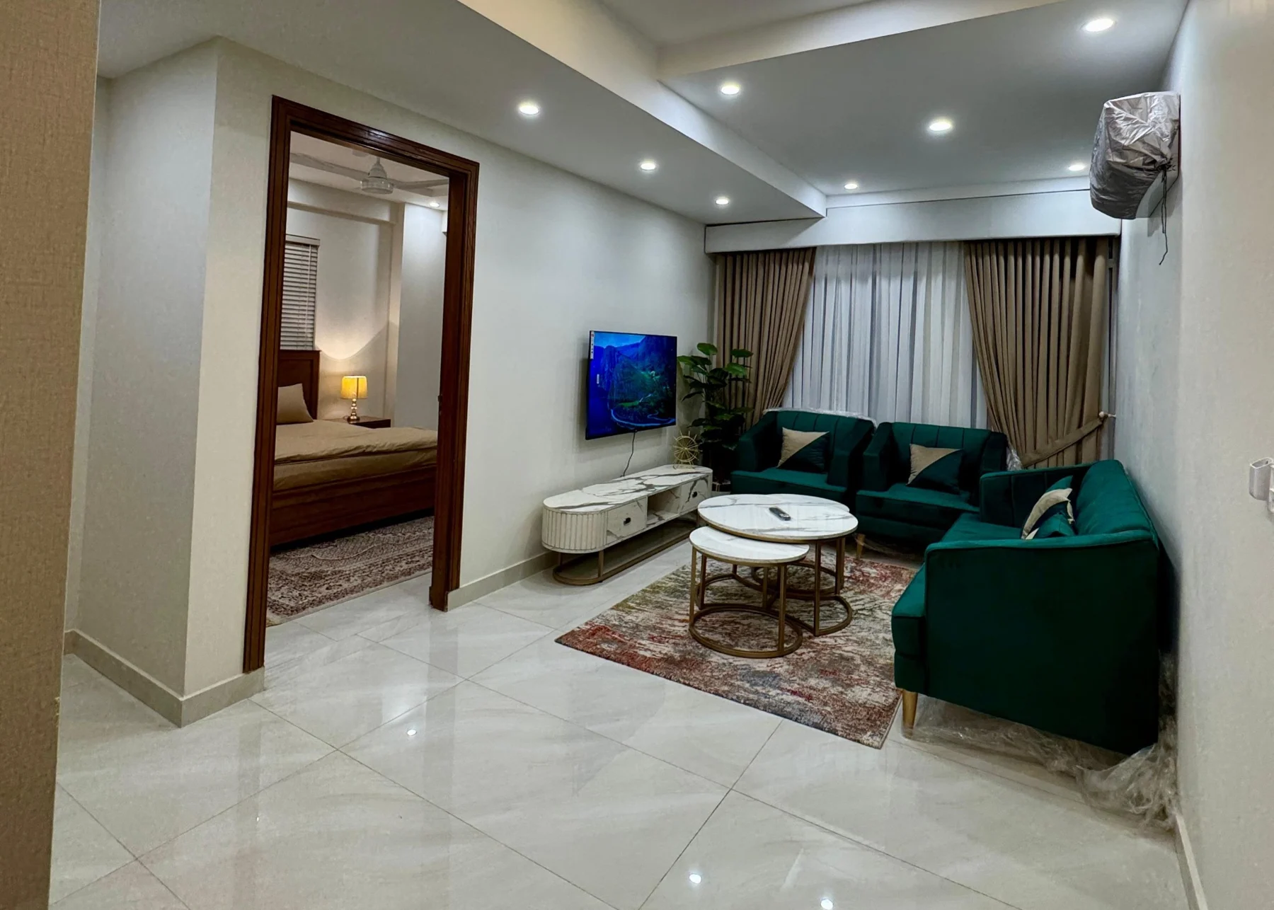Green lounge seating with an adjoining bedroom